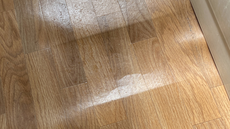 Damaged wood-looking vinyl flooring with gap in floor