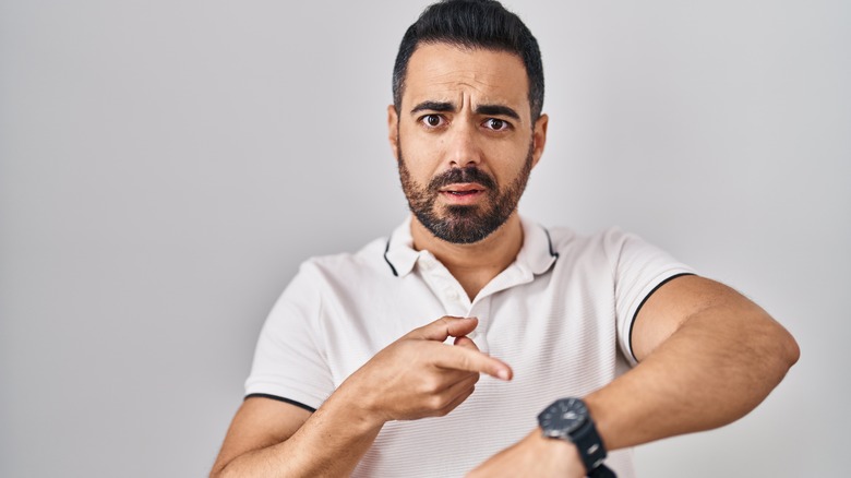 man pointing at watch