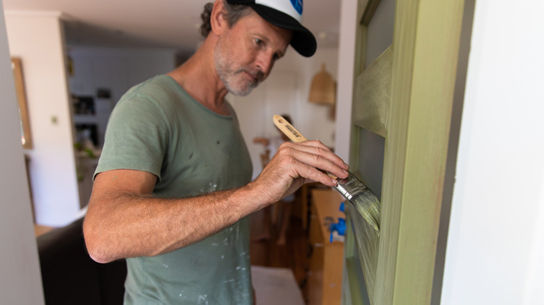 person painting a front door 