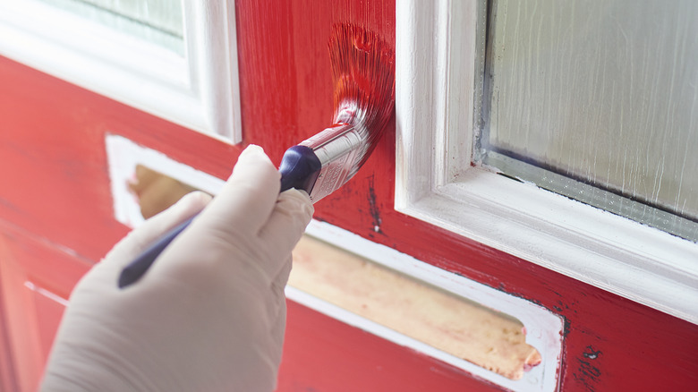 Person painting front door red
