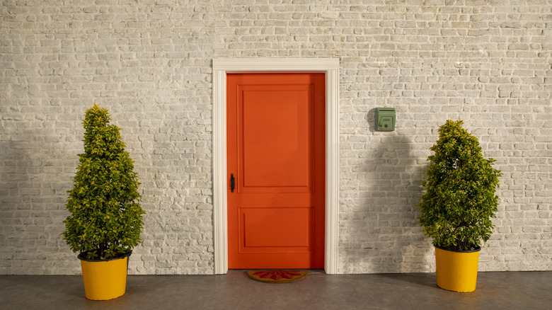 Burnt orange front door on a gray brick building