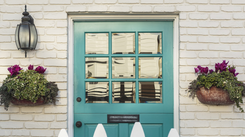 Teal door against gray-ish brick