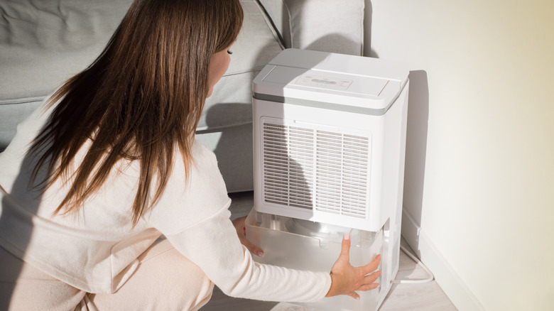 woman emptying dehumidifier