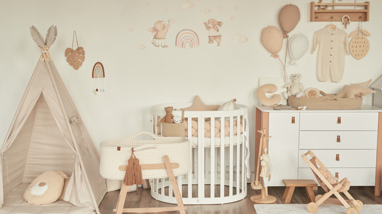 Nursery decorated in neutral tones with white furniture