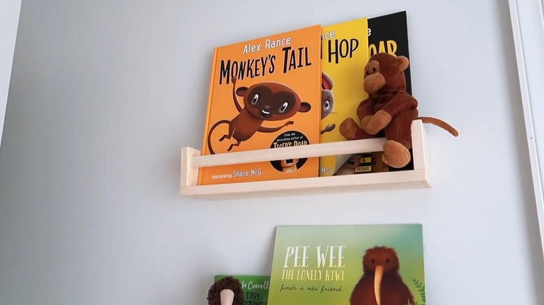 Wooden spice racks holding books on wall