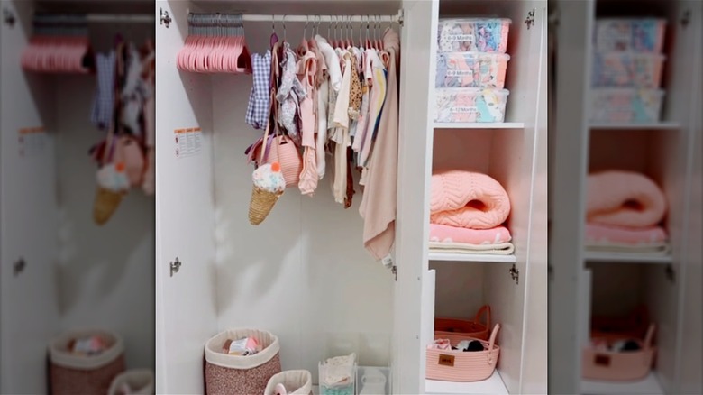 Large wardrobe with pink children's clothes and containers