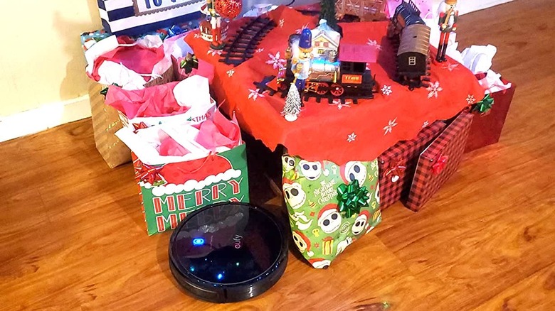 small robot vacuum cleaning around presents