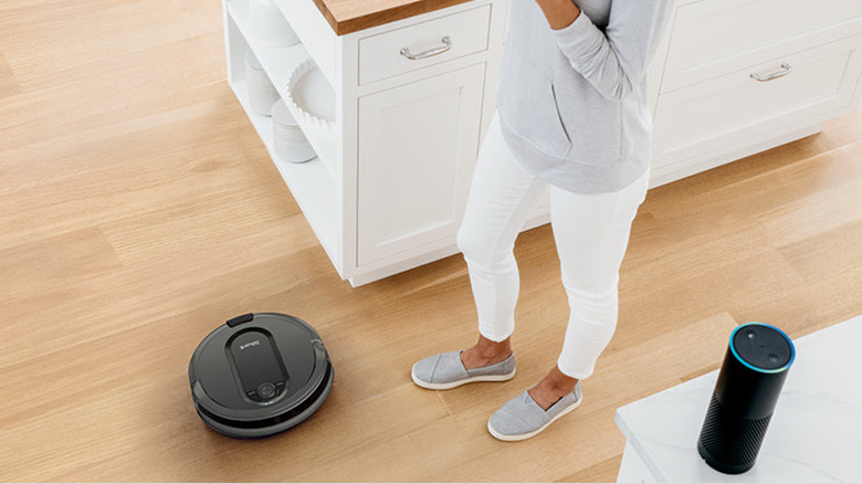 woman standing by alexa and robot vacuum