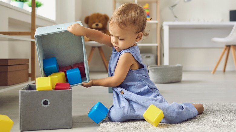 Child cleaning up their toys 