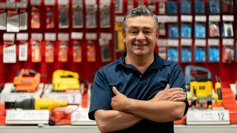 A man standing in front of a shelf of tools in a hardware store