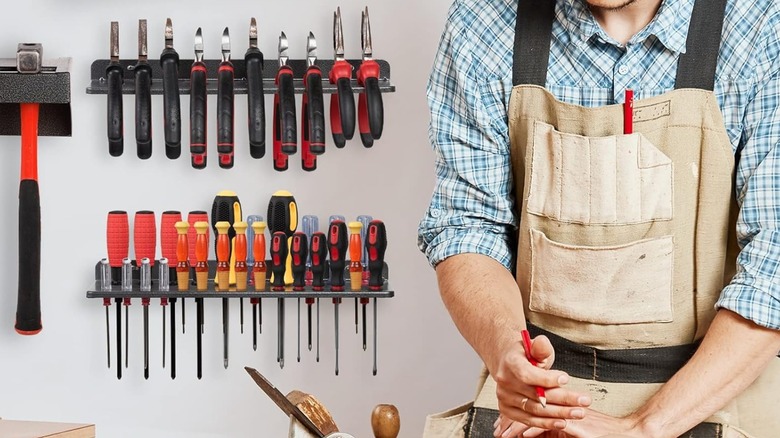 A man working in front of AHOWPD tool organizers wearing a woodworking apron