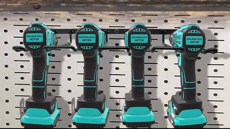 A Vikernieldrill drill organizer on a pegboard wall filled with black and teal drills