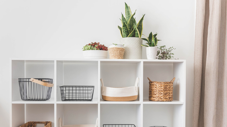 White storage cupboard full of baskets