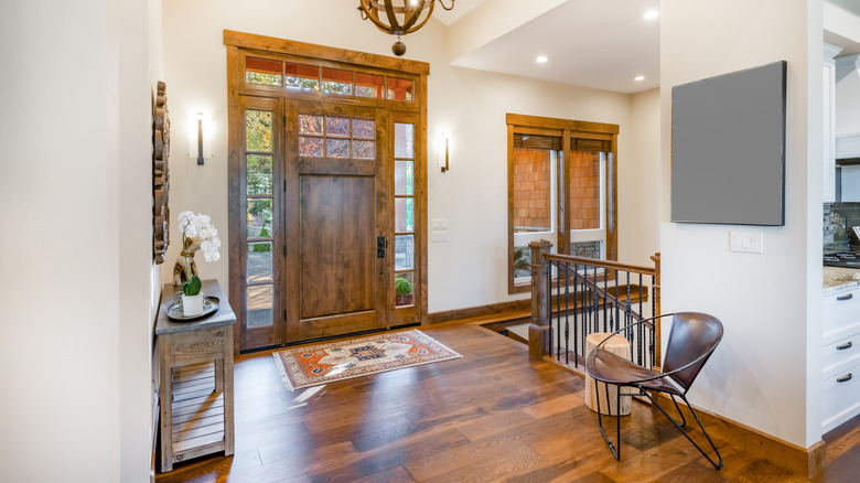 Small patterned rug in front of grand wood front door