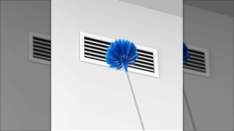 A wall vent is cleaned by a corner brush duster