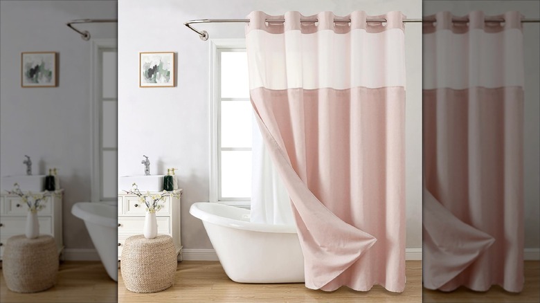 A pink shower curtain is folded back to show the snap-in liner