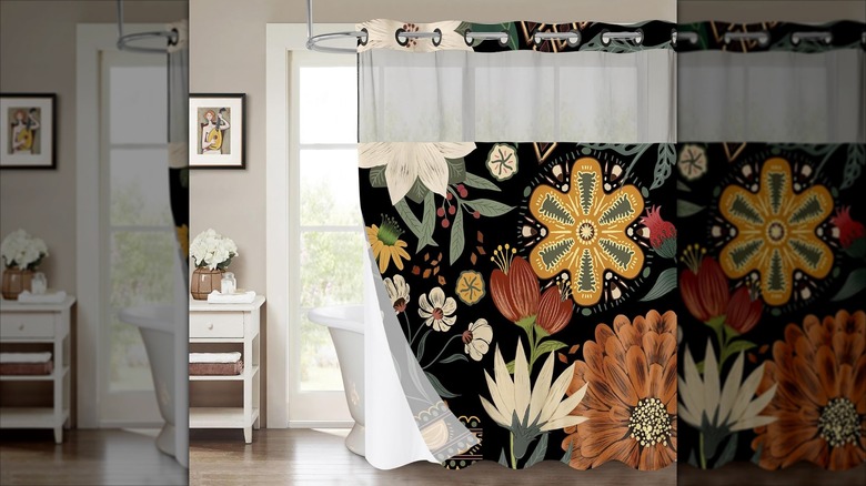 A bold floral shower curtain hangs in a neutral bathroom