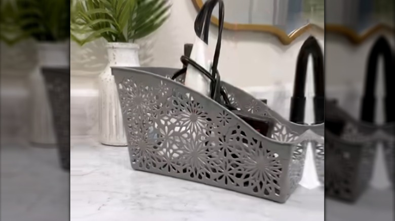 Grey plastic book bin on counter filled with white hair dryer