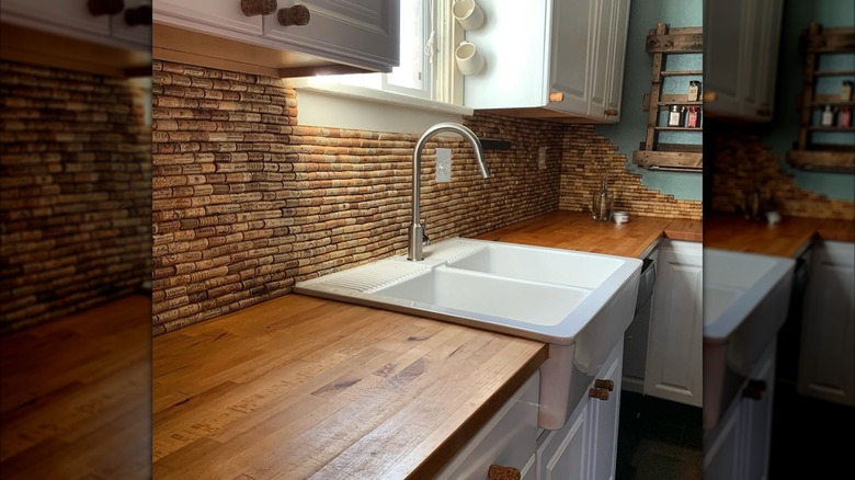 Cork backsplash behind butcher block countertops and a white sink