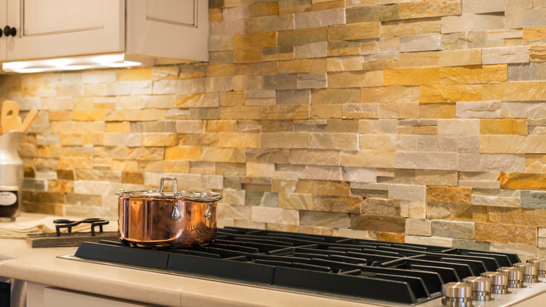 Natural stone backsplash behind a kitchen stove