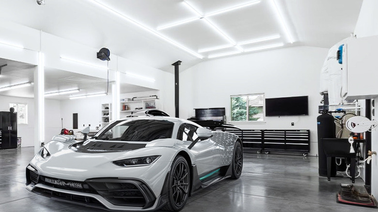 A white sports car sits inside a brightly lit garage