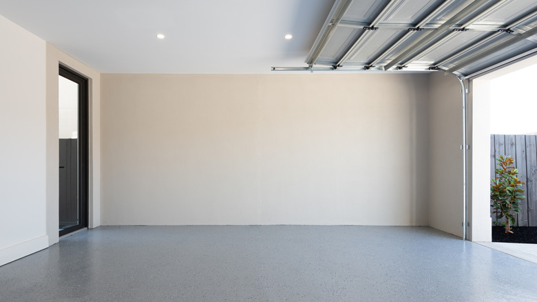 Two recessed lights are shown in an empty garage with the door open