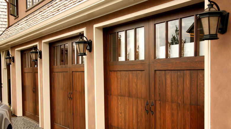 Decorative light fixtures are installed between wooden garage doors