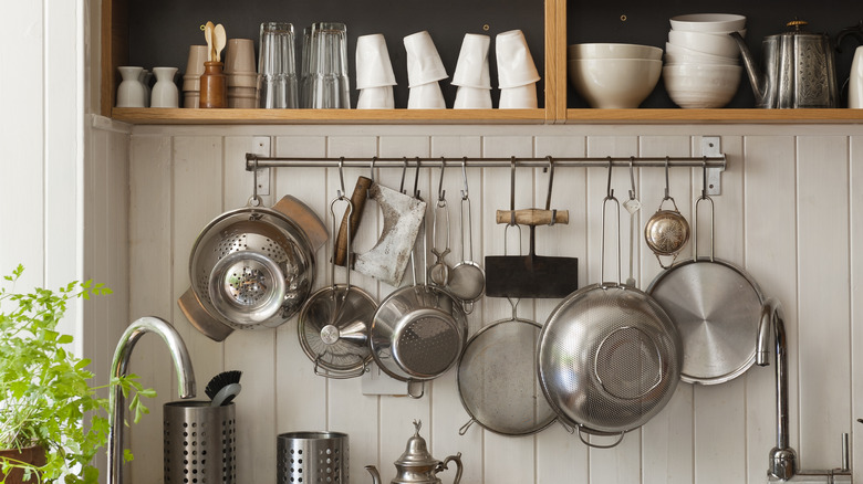 strainers hanging from kitchen rail