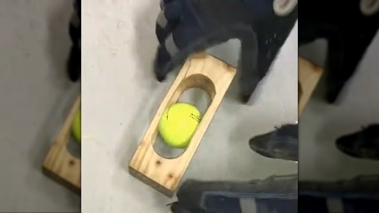 a rolling golf ball stuck inside a block of wood