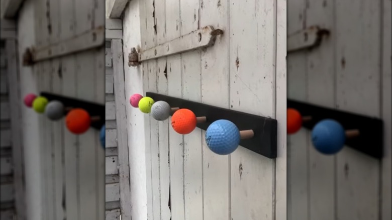 wall hook unit made from colorful golf balls hung on a rustic shed door