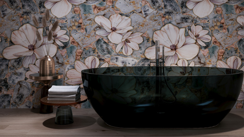 floral wallpaper behind glass bathtub