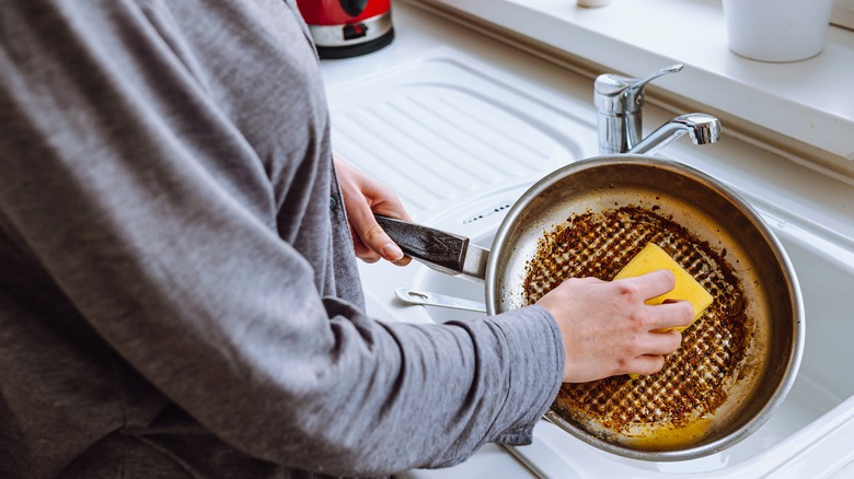 Person scrubbing out dirty pan