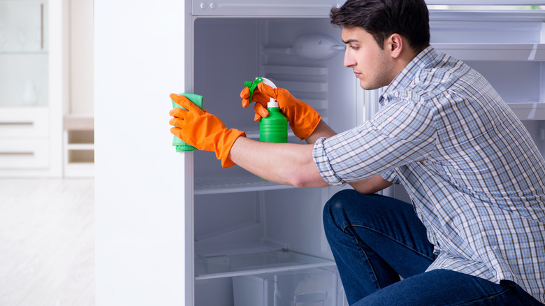 man cleaning fridge