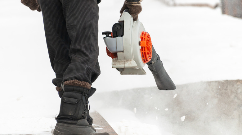 man removing snow with leaf blower