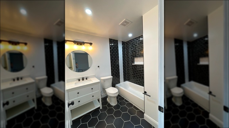 Small bathroom with black tiles on the floor and in the shower