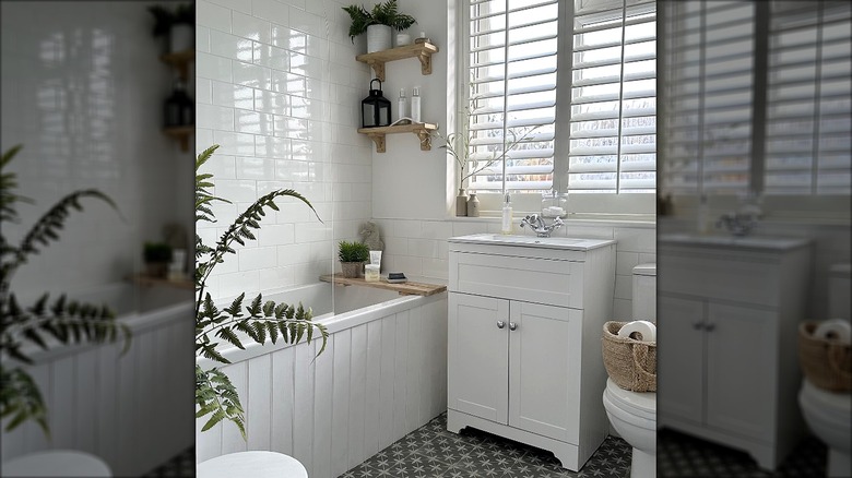 Small bathroom with glossy white tiles reflecting the light