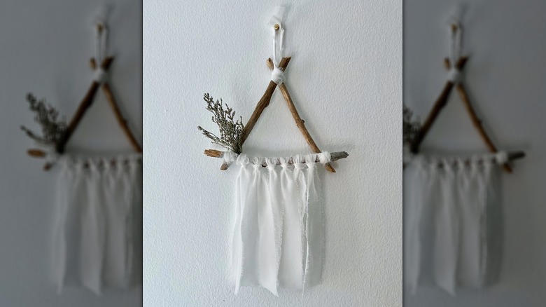 White ribbon hanging from sticks boho wall art