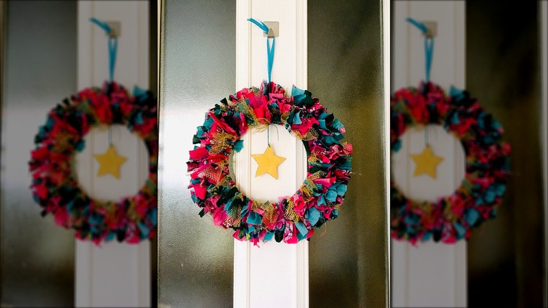 Pink, blue, black, and gold scrap ribbon wreath with a star in the middle