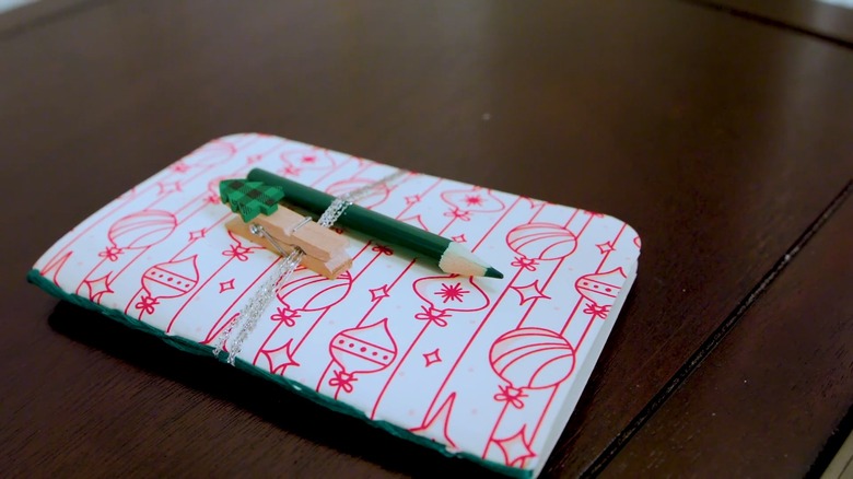 A mini notepad with pencil and Christmas clip