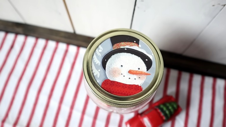 Snowman graphic on a glass jar lid