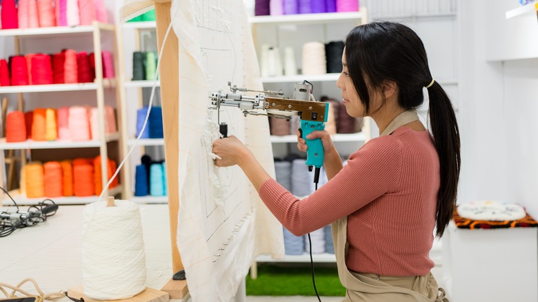 Woman creating a tufted rug