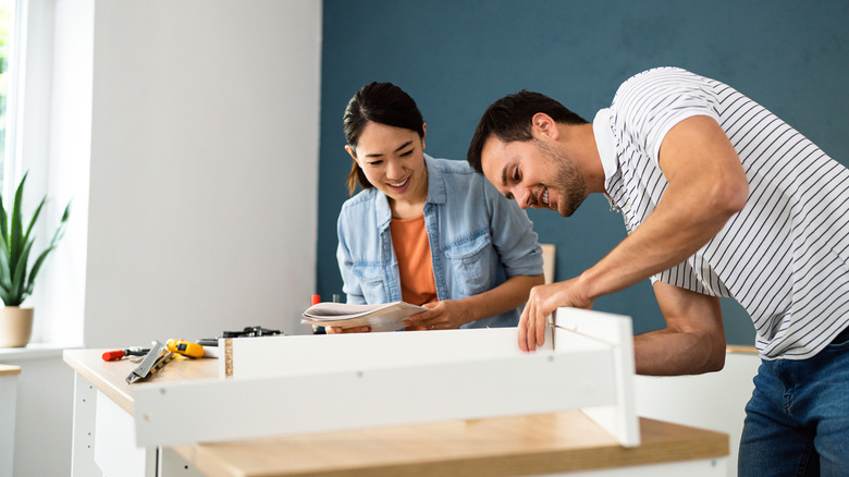 A couple working together to build furniture