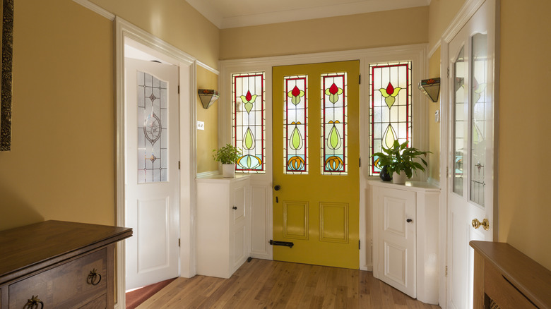 Home entryway in a bold mustard yellow paint color