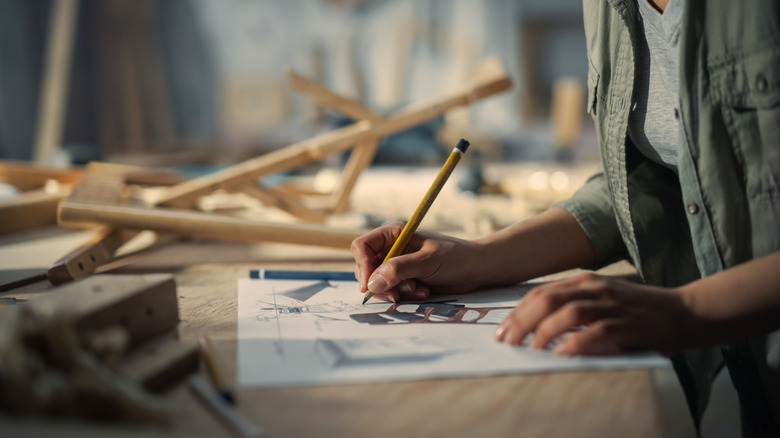 Hands of a person designing an artisanal chair