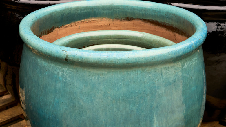 A set of teal terra cotta pots stacked together