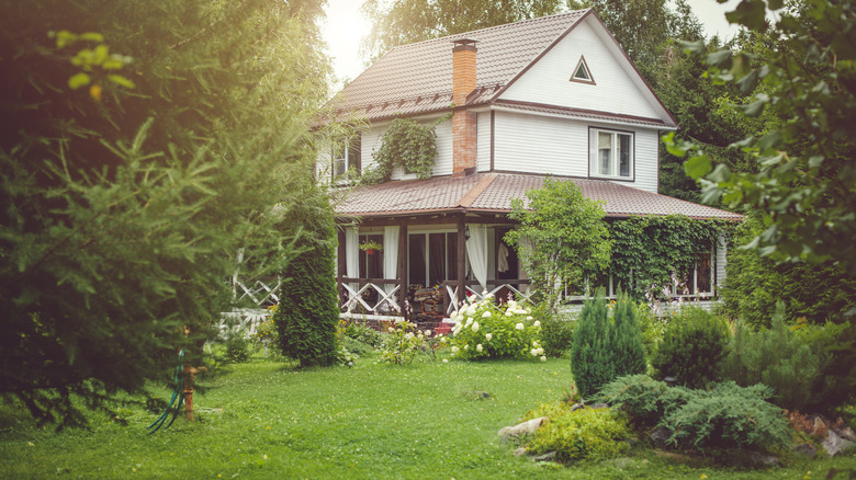 A white cottage with beautiful green landscaping