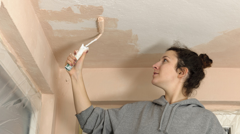 Woman painting ceiling