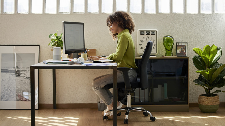 woman sits in home office chair