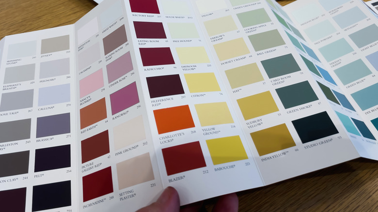 Paint swatches and samples from Farrow and Ball laid across a wooden table