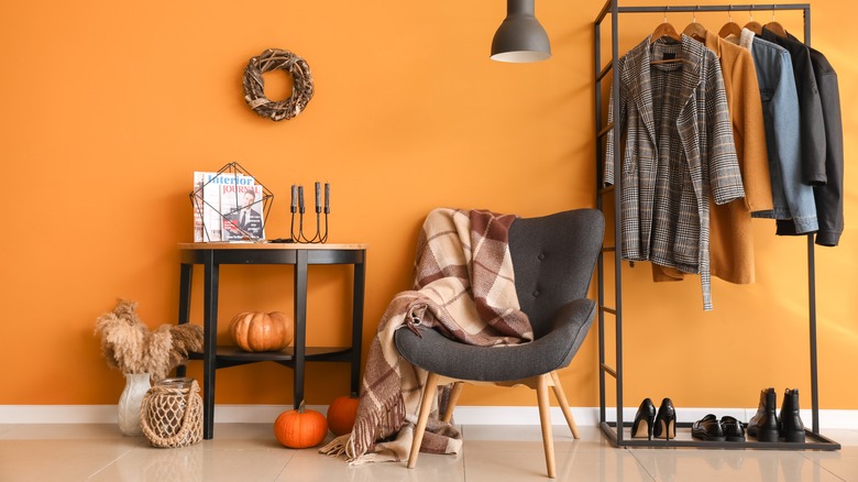 orange accent wall with decor and chair
